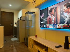 a living room with a tv and a refrigerator at Destina Stays, Cozy & Netflix @Air Residences, Makati, Metro Manila in Manila