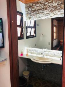 uma casa de banho com um lavatório e um espelho em Casa na Enseada- Guaruja no Guarujá
