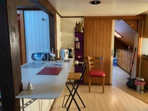 una cucina con bancone bianco e sedie in camera di Sonderbar Home a Schwyz (Svitto)