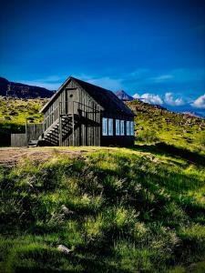 an old barn sitting on a grassy hill at Hraunsnef Country Hotel in Bifrost
