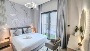 een slaapkamer met een bed, een stoel en een raam bij STAY BY LATINEM Luxury 2BR Holiday Home CV A2301 near Burj Khalifa in Dubai