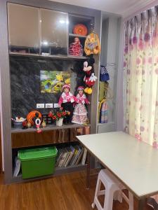 una habitación con una mesa y algunos juguetes en un estante en bom bomm home for lovery, en Bangna