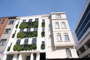 een wit gebouw met planten aan de zijkant bij AB Residences -Cihangir Luxury Antique Apartment in Istanbul