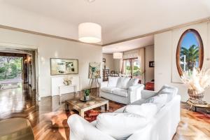 een woonkamer met witte banken en een tafel bij Villa Solatia in Massa Lubrense
