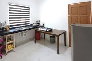 eine Küche mit einem Waschbecken und einem Holztisch in der Unterkunft Singgah Homestay in Kuala Terengganu