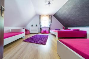 a room with two beds and a purple rug at Emilia domki U Przyjaciół in Żarnowska