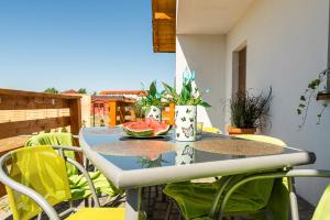 a table with a plate of watermelon on a balcony at Emilia domki U Przyjaciół in Żarnowska