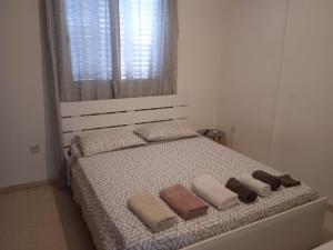 a bedroom with a bed with three pillows and a window at Larnaca, Pervolia 1 bedroom seaside apartment in Pervolia