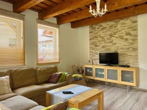 a living room with a couch and a tv at Rekreačný domček TIŽINA in Terchová