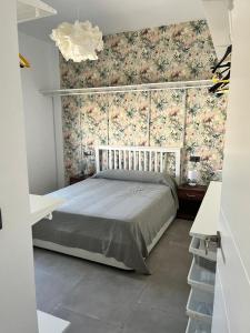 1 dormitorio con cama y papel pintado con motivos florales en Chalet en Montellano (Sevilla), en Montellano