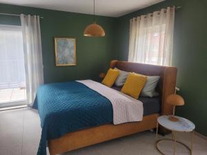 a bedroom with a bed with a blue blanket and yellow pillows at Pension & Ferienwohnung Oberhof 810 M in Oberhof