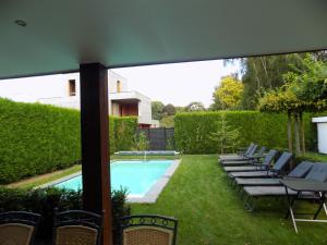 eine Terrasse mit Stühlen und einem Pool in der Unterkunft Villa Maas & Kempen in Maaseik