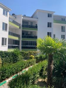 an apartment building with a palm tree in front of it at Mudanya Falez Evleri. in Mudanya