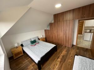 a small bedroom with a bed and wooden floors at Apartman Vuk Zlatar in Brdo
