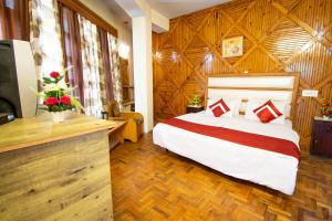 a hotel room with a bed and a television at Octave Himalayan Hamlet in Kulu