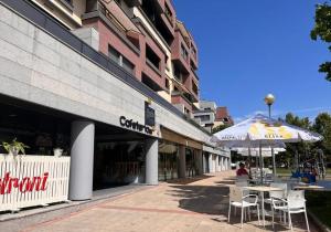 um edifício com guarda-sol, mesas e cadeiras em Apartamento Mercedes em Logroño