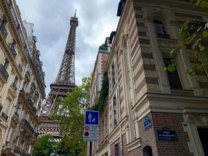uitzicht op de eiffeltoren tussen twee gebouwen bij Grand Appartement - Tour Eiffel in Parijs
