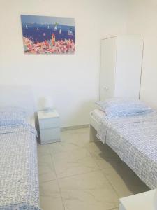 a bedroom with two beds and a picture on the wall at Villa Sole Tisno in Tisno