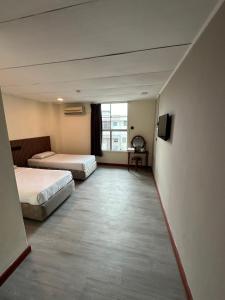 a hotel room with two beds and a television at CU Boutique Hotel in Kota Kinabalu