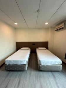 two beds in a small room with two at CU Boutique Hotel in Kota Kinabalu
