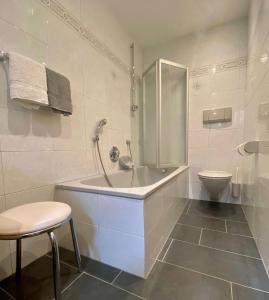 ein weißes Bad mit einer Badewanne und einem WC in der Unterkunft App. Cesa Vedla in St. Ulrich in Gröden