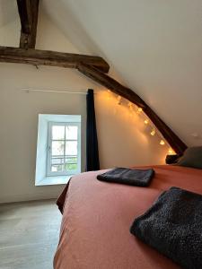Schlafzimmer mit einem Bett und einem Fenster in der Unterkunft T2 atypique et chaleureux in Baugé