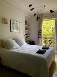 una camera da letto con un grande letto bianco e una finestra di Grand Appartement - Tour Eiffel a Parigi