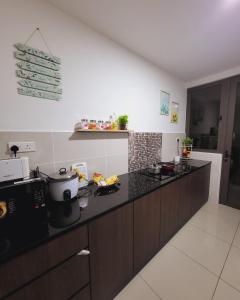a kitchen with a black counter top in a room at Bali Residence Impian Raudah in Melaka