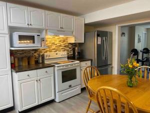 a kitchen with white cabinets and a table and a microwave at 4 bedroom apartment on 75 acre farm in Tillsonburg