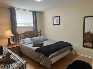 a bedroom with a bed with a black blanket on it at 4 bedroom apartment on 75 acre farm in Tillsonburg