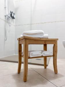 - une petite table en bois avec des serviettes dans la salle de bains dans l'établissement Pascoli 21/A, à Ravenne