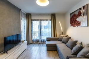 a living room with a couch and a flat screen tv at K40 Boutique Apartment in the City Center in Budapest