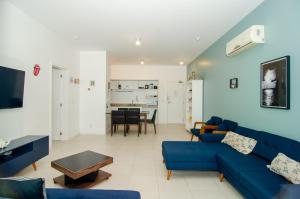 a living room with a blue couch and a table at Apto Vista Mar com acesso a Praia do Santinho QM9528 in Florianópolis