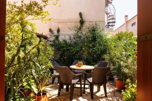 eine Terrasse mit einem Tisch, Stühlen und Pflanzen in der Unterkunft Olga's Cozy home in Monemvasia