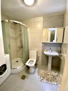 a bathroom with a shower toilet and a sink at KENT Apartments in Pristina