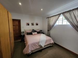 una camera con letto e finestra di Six Valk Avenue Guest House a Johannesburg