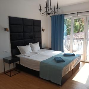 a bedroom with a large bed with a large window at Holiday Apartment ORA in Balchik