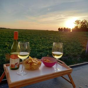 una mesa con dos copas de vino y un tazón de comida en De Molenlos en Zottegem