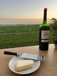 un pezzo di formaggio su un piatto accanto a una bottiglia di vino di De Molenlos a Zottegem