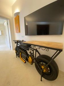a table with a tv and a wheel under it at The White Knight Premium Boutique Hotel in Għajnsielem