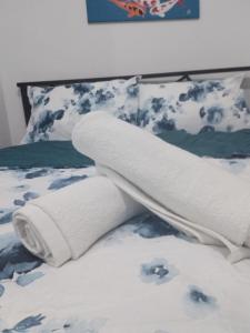 a roll of white towels on a bed at Nearby Airport T3 at Stamford Mckinley hill few walk to Venice Piazza T116F in Manila