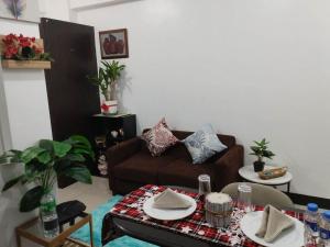 uma sala de estar com um sofá e uma mesa em Nearby Airport T3 at Stamford Mckinley hill few walk to Venice Piazza T116F em Manilla