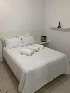 a white bed with two towels on top of it at Apartamento em Maceió a beira mar in Maceió +8 photos