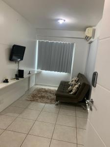 een woonkamer met een bank en een televisie bij Apartamento em Maceió a beira mar in Maceió