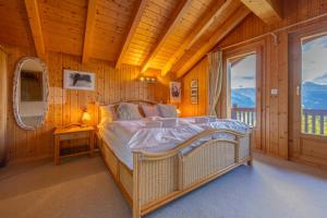 ナンダにあるChalet Marianne - Close to ski lift Nendaz - 4 Valleysの木製の部屋に大型ベッドが備わるベッドルーム1室が備わります。