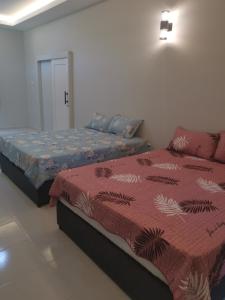 a bedroom with two beds in a room at Anjung Barakah Chalet in Kuala Terengganu