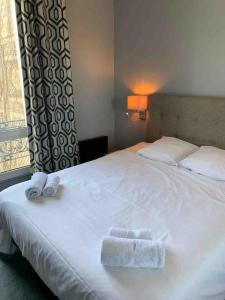 sypialnia z łóżkiem z dwoma ręcznikami w obiekcie Cosy 3 Pièces en face de la gare w mieście Rambouillet