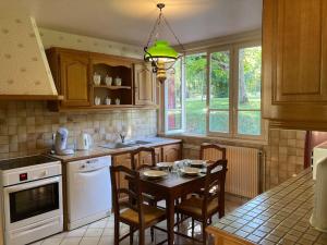 a kitchen with a table and chairs and a dining room at Longère du Perche in Montigny-le-Chartif