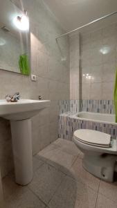łazienka z umywalką, toaletą i wanną w obiekcie Pension Suiza w mieście Reus