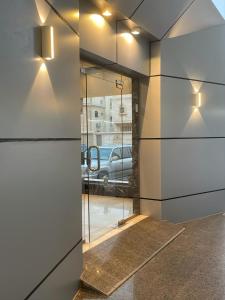 Una habitación con una puerta de cristal con un coche en la ventana. en White Beach Hotel Suites, en Rabigh